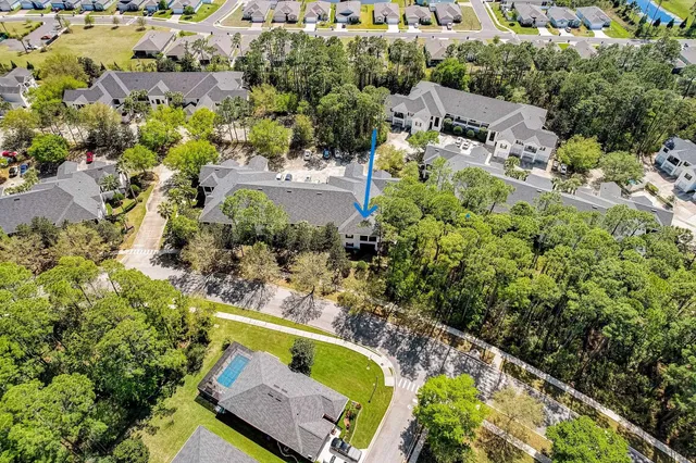 a swimming pool with outdoor seating and covered with trees