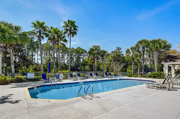 a view of a deck with wooden floor and fence next to a yard