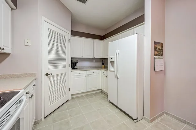 a kitchen with white cabinets and white appliances