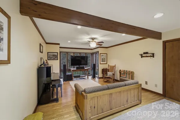 a living room with furniture a flat screen tv and a refrigerator
