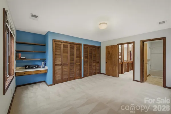 a large bedroom with closet and large window