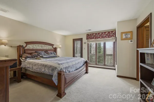 a bedroom with a bed lamp and a large window