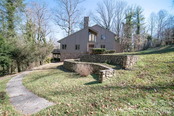 a view of a house with backyard and trees