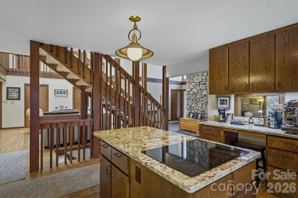 a kitchen with a stove a kitchen island a sink and dishwasher a oven with wooden cabinets