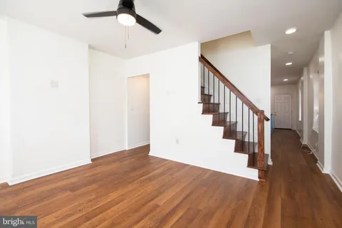 a view of a hallway with wooden floor and staircase