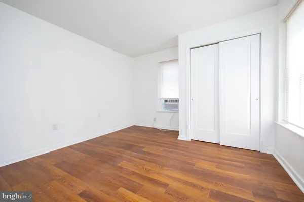 a view of empty room with wooden floor