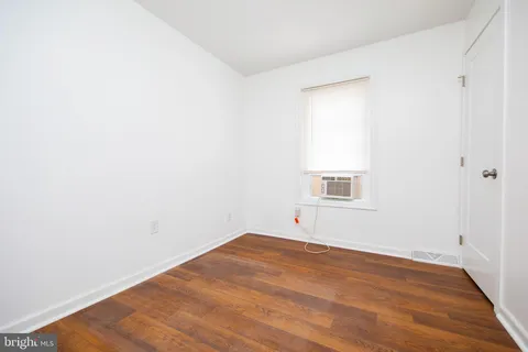 a view of a room with wooden floor and white walls