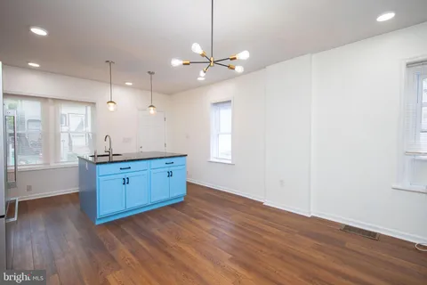a kitchen with wooden floors and white walls