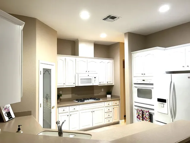 a kitchen with a refrigerator and a stove top oven