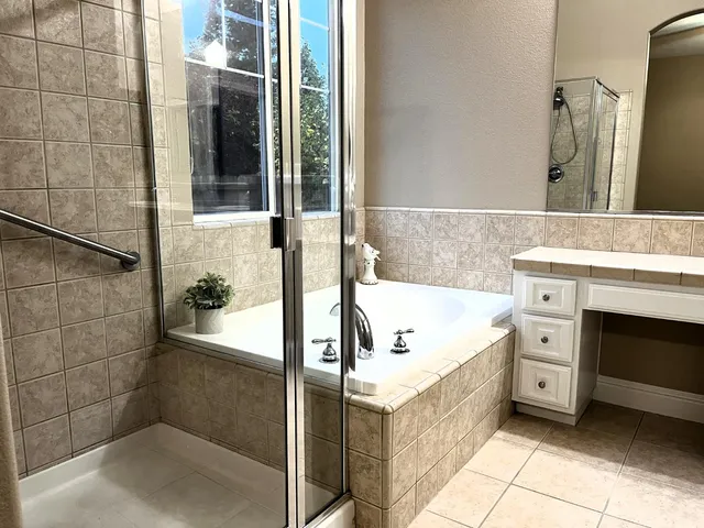 a spacious bathroom with a tub a sink and a shower