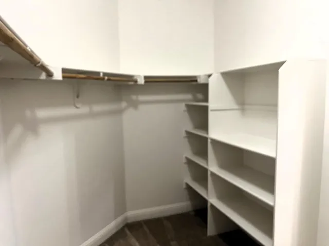 a view of walk in closet with empty racks