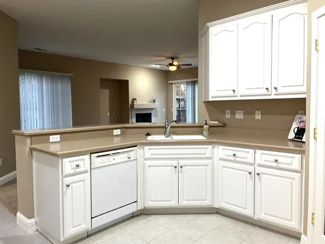 a kitchen with white cabinets and white appliances