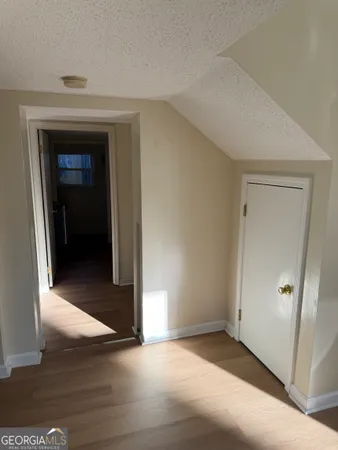 an empty room with wooden floor and entrance