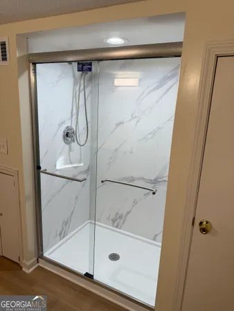 a bathroom with a glass shower door and a mirror