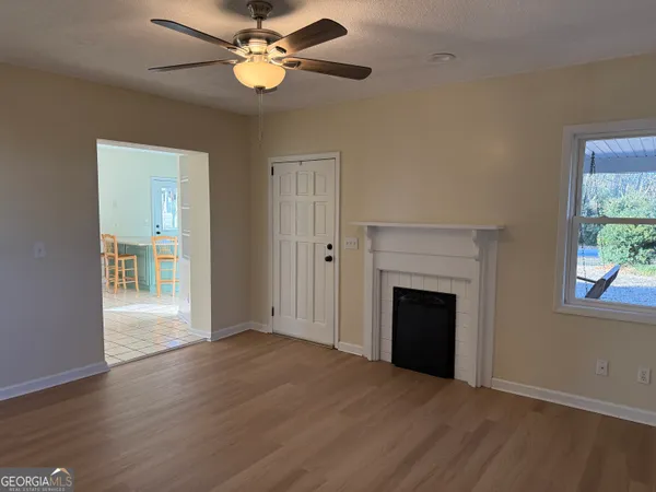 a view of an empty room with a fireplace and a window