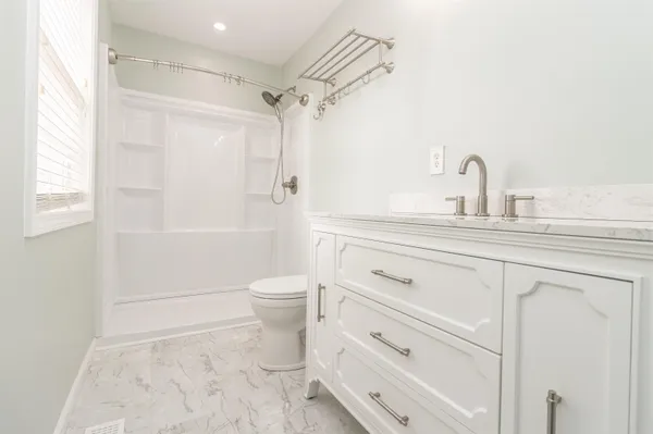 a bathroom with a sink a toilet and shower