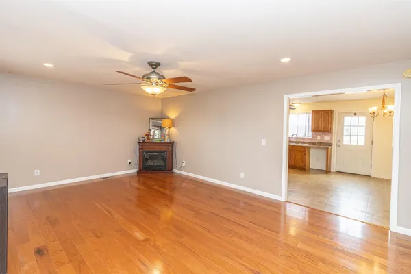 a view of an empty room with a window and wooden floor