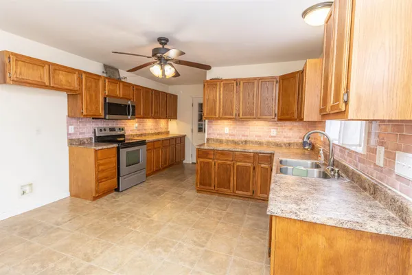 a kitchen with stainless steel appliances granite countertop a stove sink and cabinets