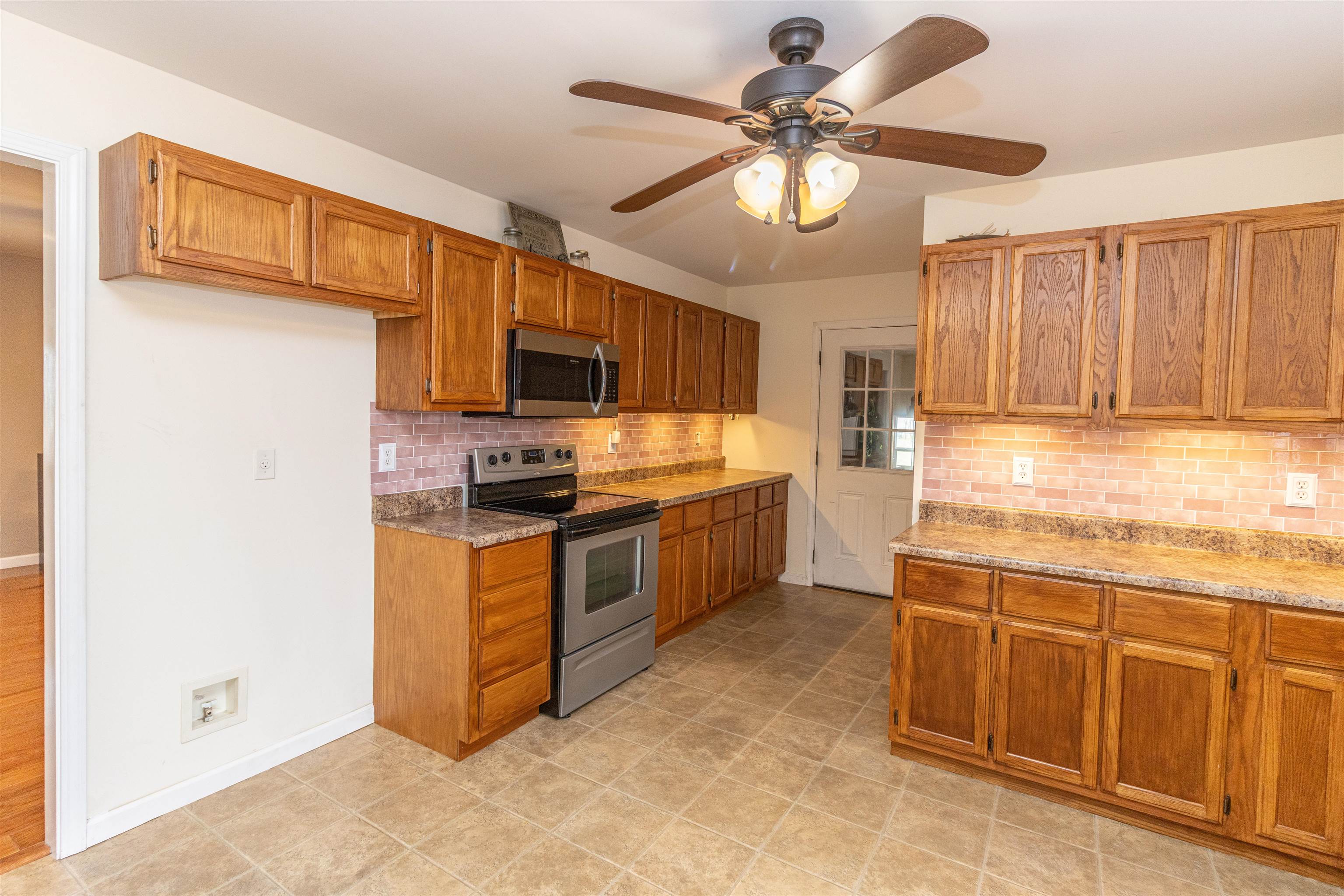 1468 Matrose Carroll Road Michie, TN 38357 - Photo 9 of 27 a kitchen with stainless steel appliances granite countertop a stove refrigerator and cabinets