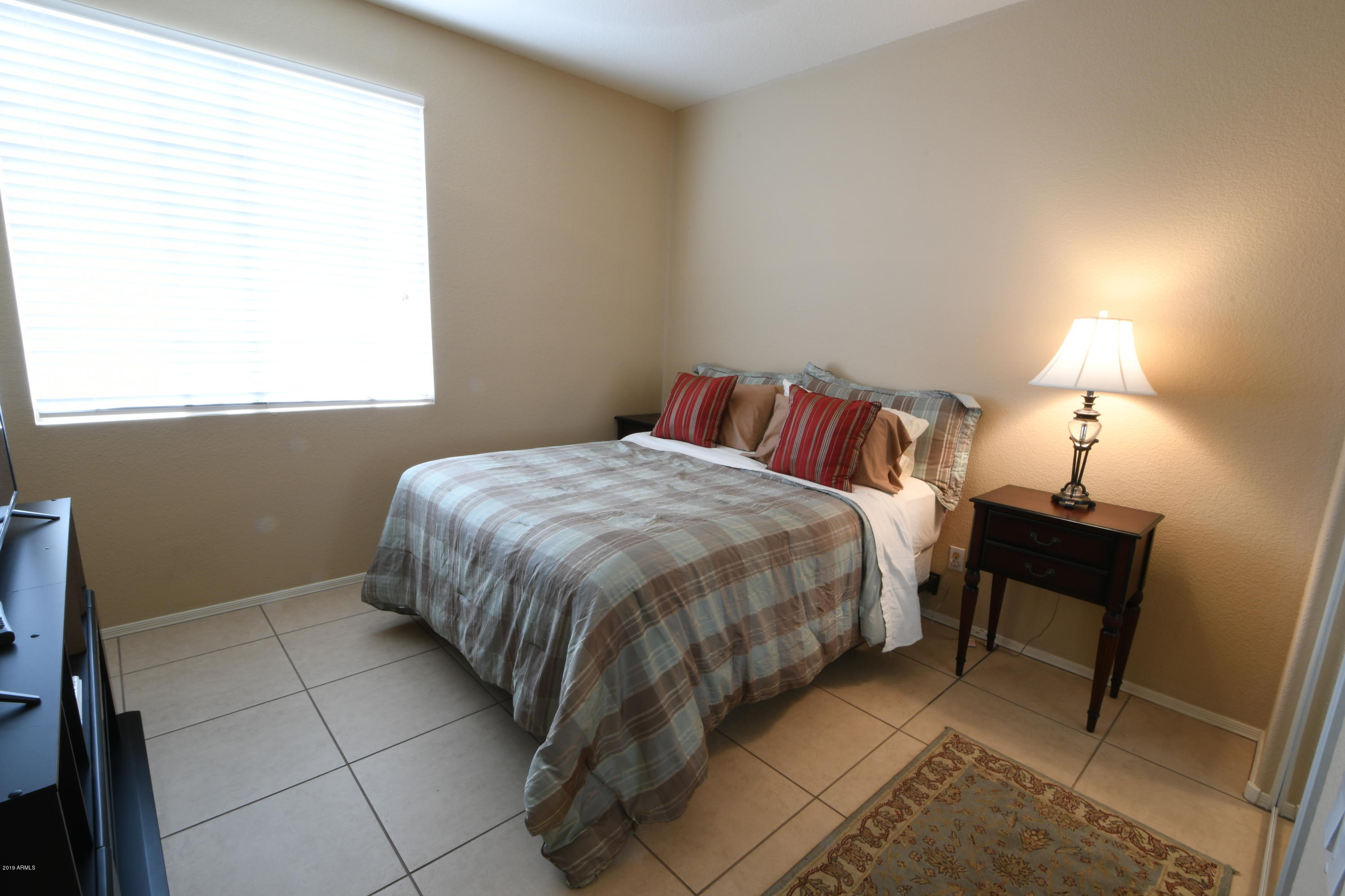 2226 West Carson Road Phoenix, AZ 85041 - Photo 20 of 29 a bed sitting in a bedroom next to a window