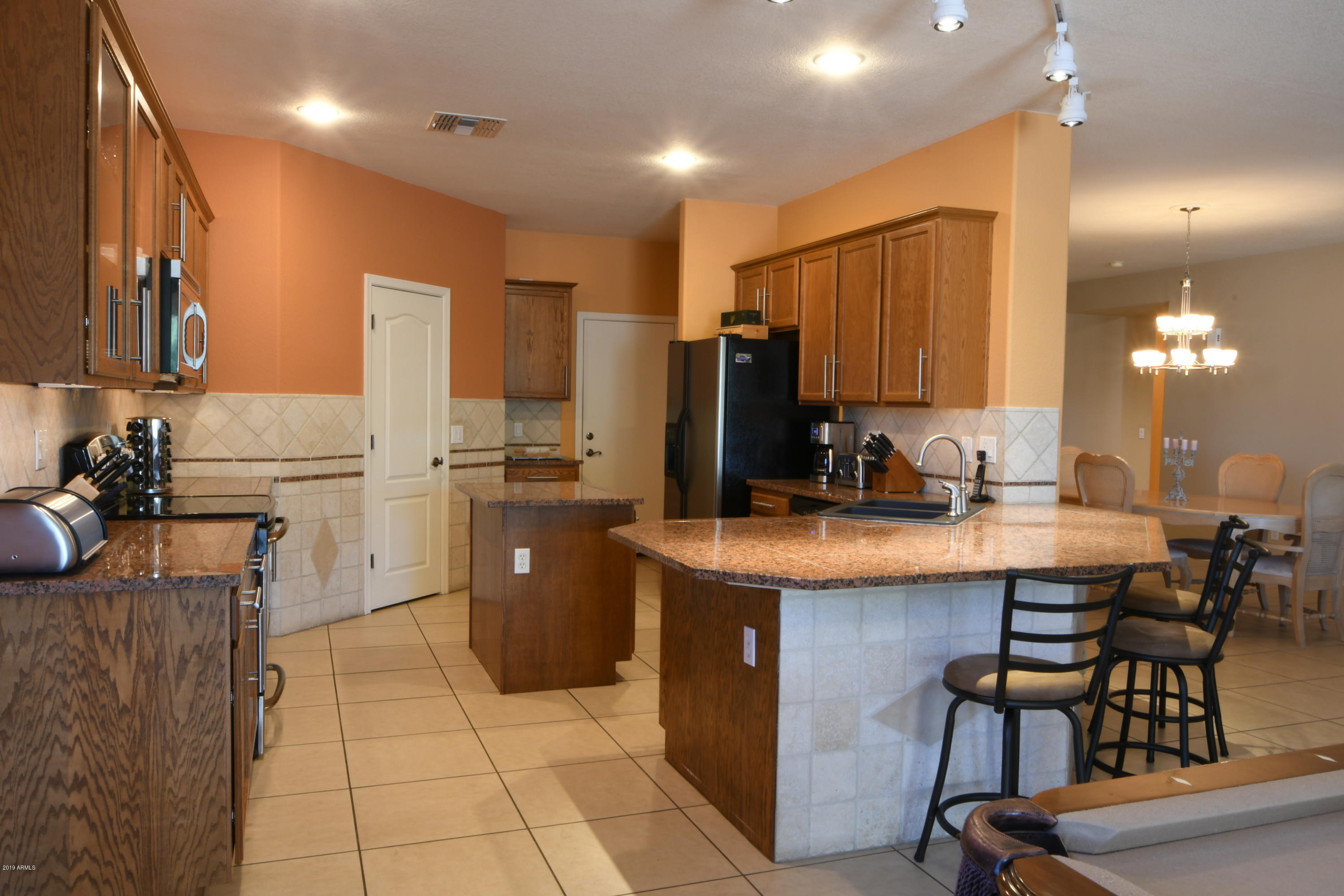 2226 West Carson Road Phoenix, AZ 85041 - Photo 5 of 29 a kitchen with cabinets and chairs