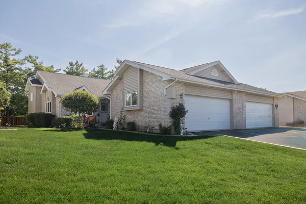 a front view of a house with a garden and yard