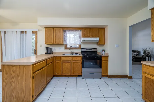 a kitchen with a sink a stove top oven and cabinets