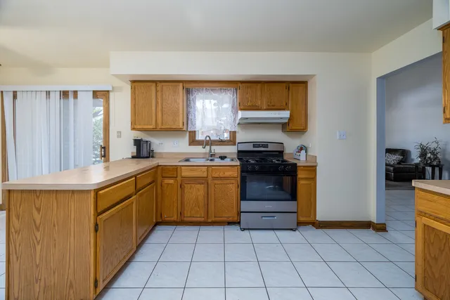 a kitchen with a sink a stove top oven and cabinets
