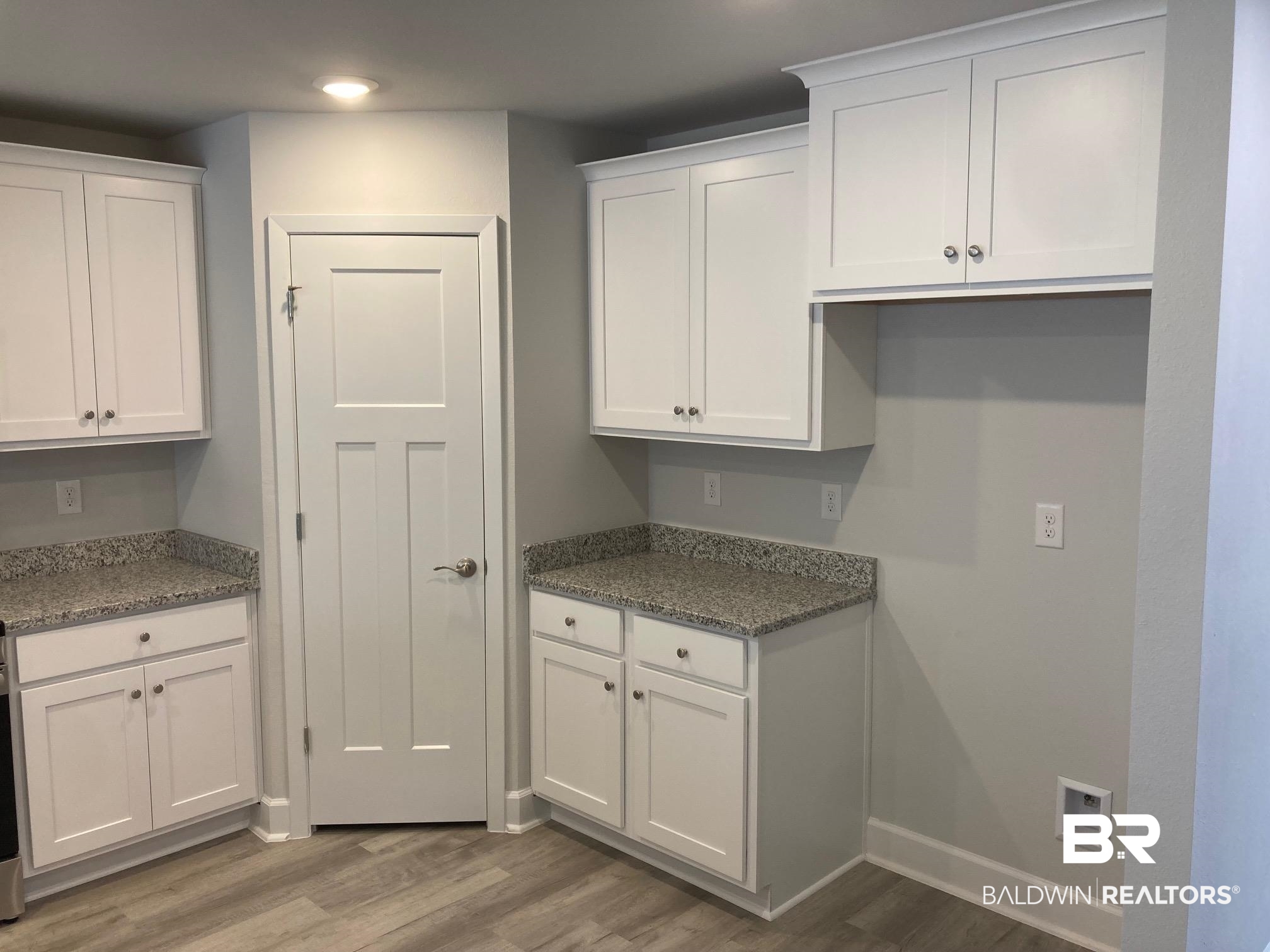 705 Mayflower Drive Foley, AL 36535 - Photo 6 of 19 Kitchen featuring baseboards, white cabinetry, light stone countertops, and light wood-style floors