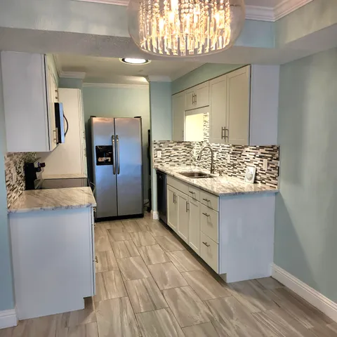 a kitchen with stainless steel appliances granite countertop a stove a sink and a refrigerator