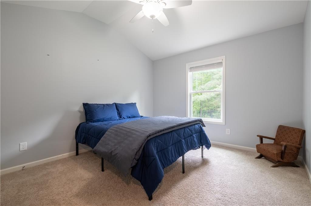 719 Fairview Road Brooks, GA 30205 - Photo 23 of 35 a spacious bedroom with a bed and a chandelier