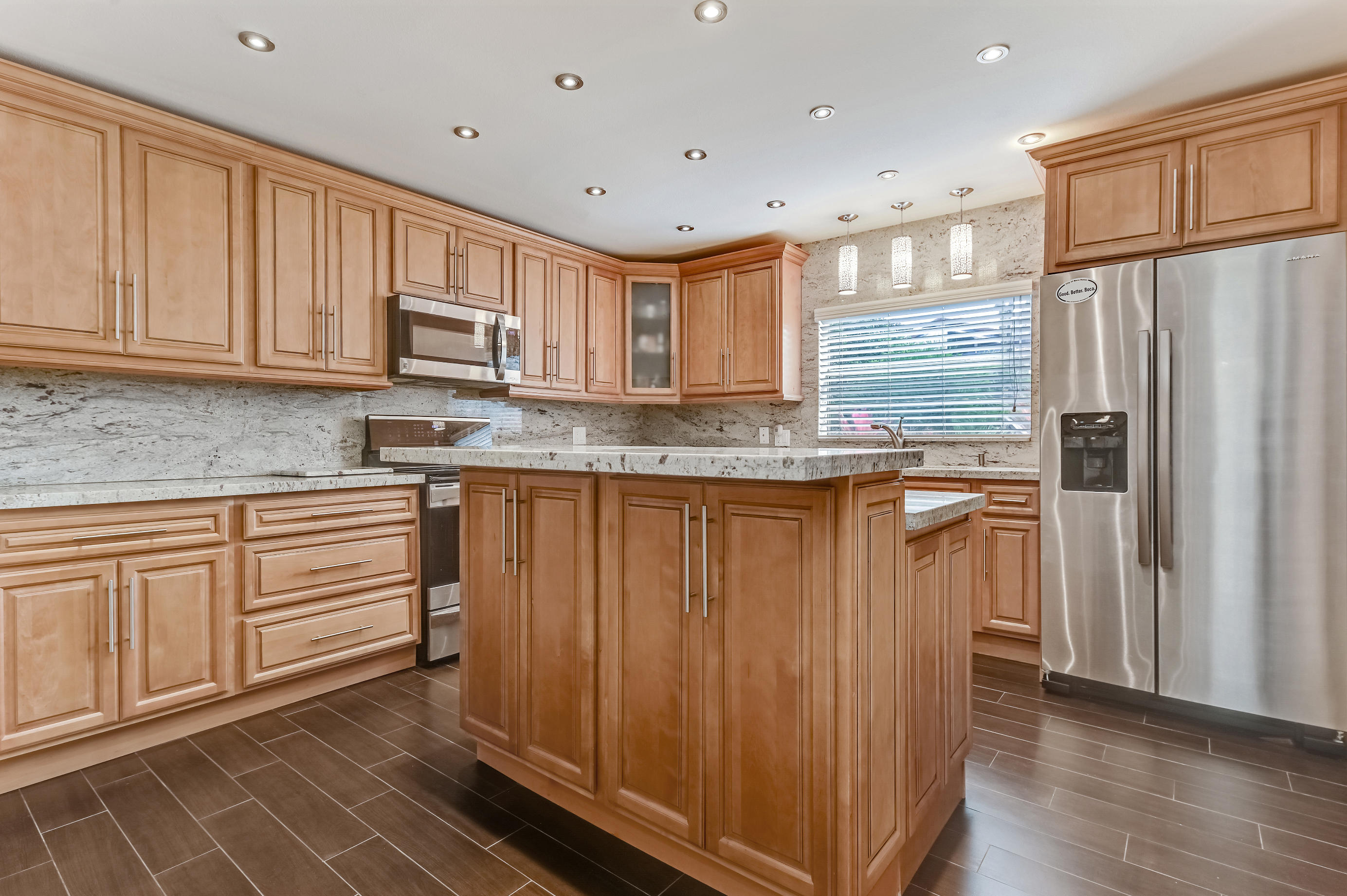 9300 Vista Del Lago, Unit 6B Boca Raton, FL 33428 - Photo 10 of 22 a kitchen with stainless steel appliances granite countertop a refrigerator sink and cabinets