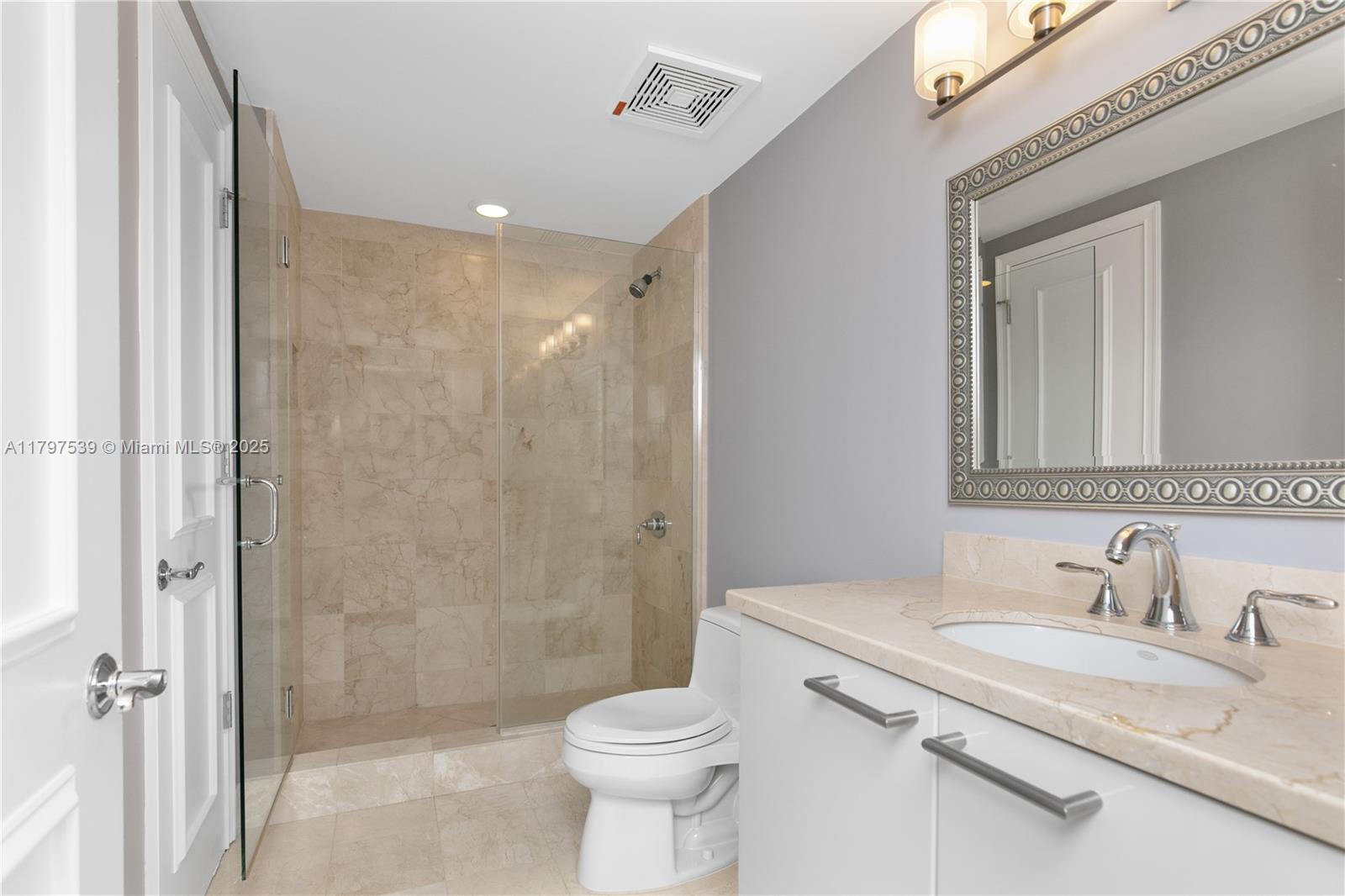 3350 Southwest 27th Avenue, Unit 902 Miami, FL 33133 - Photo 30 of 40 a bathroom with a granite countertop sink toilet and shower