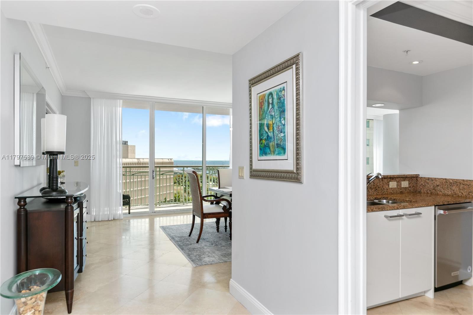 3350 Southwest 27th Avenue, Unit 902 Miami, FL 33133 - Photo 6 of 40 a kitchen with granite countertop a stove and a refrigerator