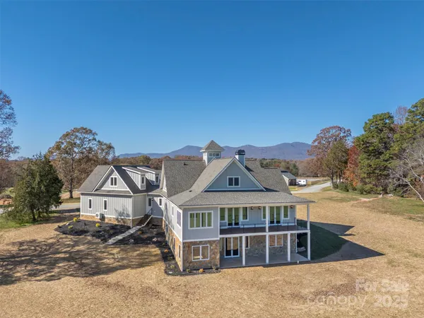 a view of a big house with a big yard and large tree