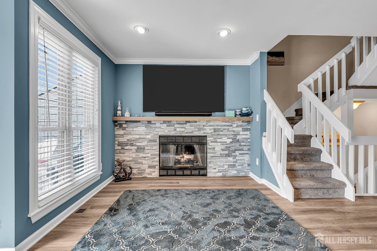 303 Spinnaker Way Neptune, NJ 07753 - Photo 14 of 54 a living room with a fireplace and a flat screen tv