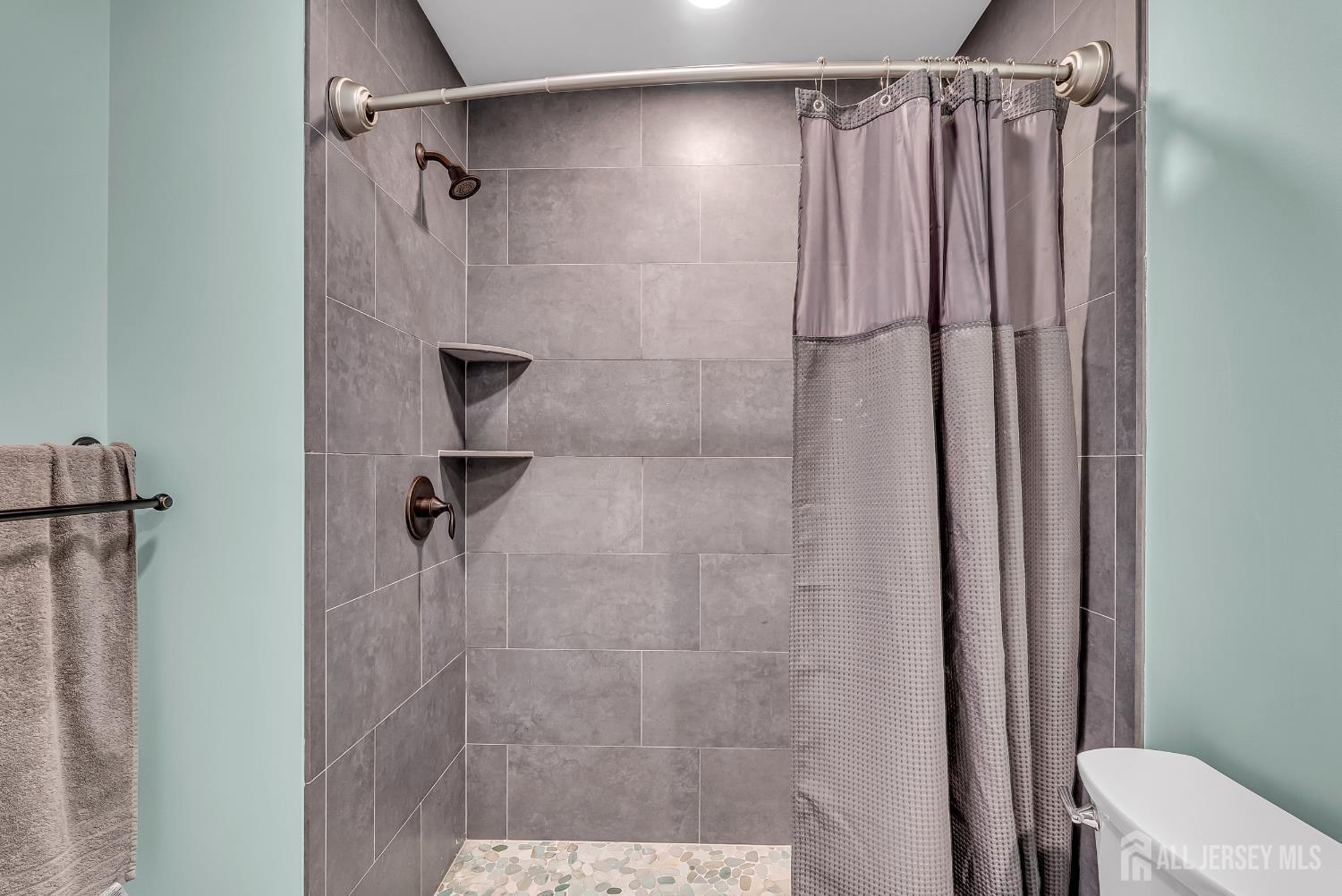 303 Spinnaker Way Neptune, NJ 07753 - Photo 34 of 54 a bathroom with a shower and a toilet