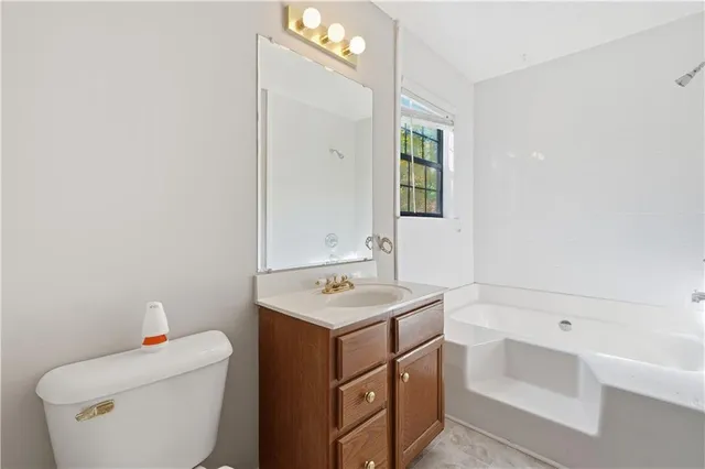 a bathroom with a sink toilet vanity and tub