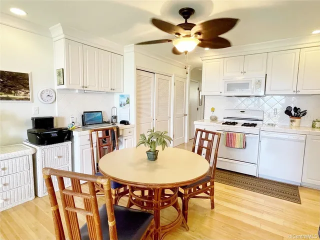 a kitchen with stainless steel appliances a dining table chairs and white cabinets