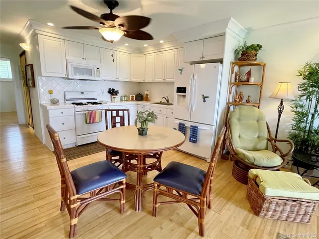 a kitchen with stainless steel appliances granite countertop a dining table and chairs