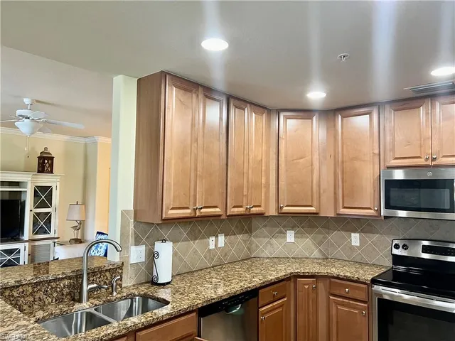 a kitchen with stainless steel appliances granite countertop a sink a stove and cabinets