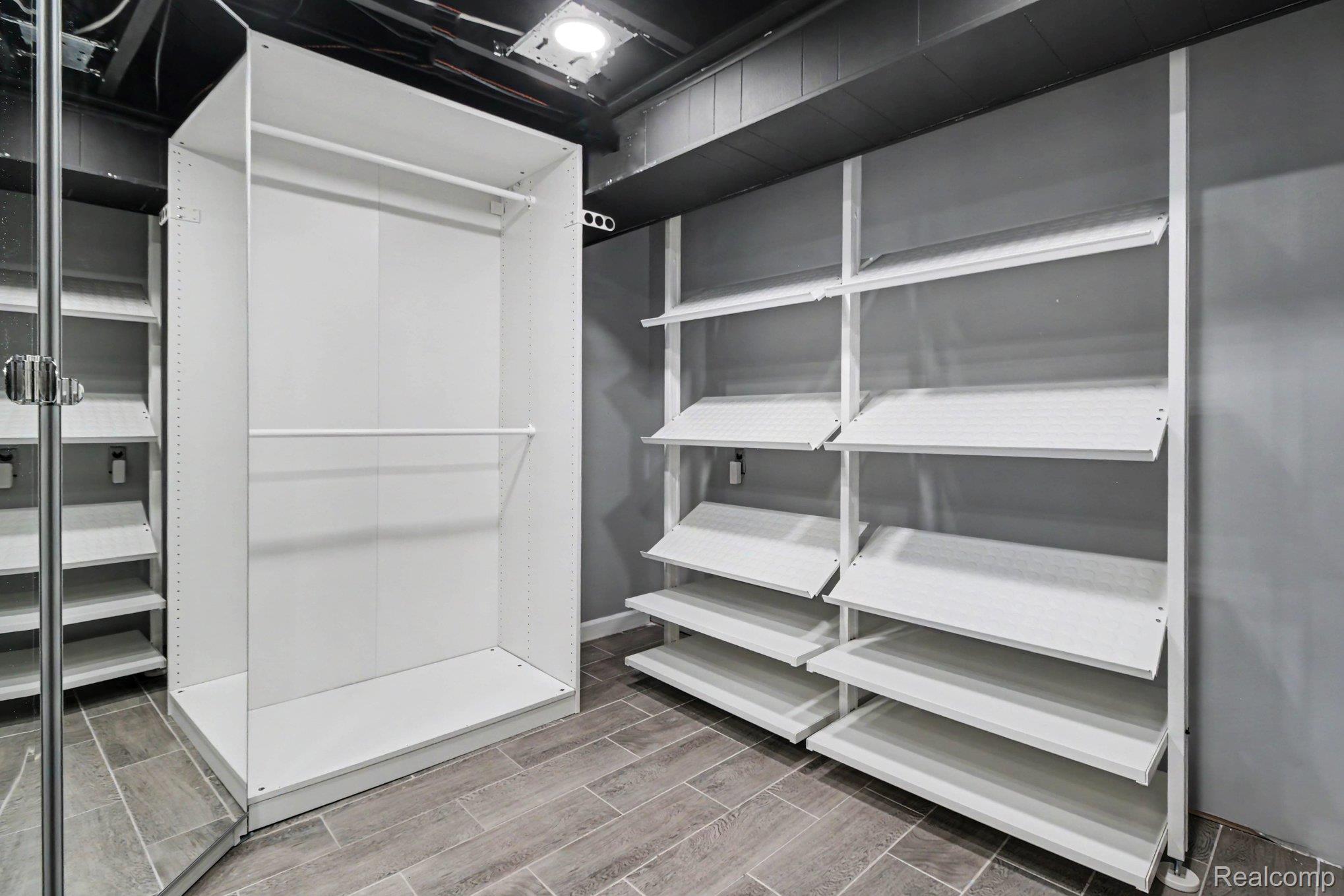 2373 Rutherford Road Bloomfield Hills, MI 48302 - Photo 20 of 28 Customizable closet system with built-in shelving, hanging rods, and wood-finish flooring