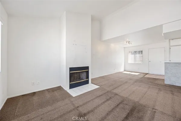 a view of empty room with kitchen