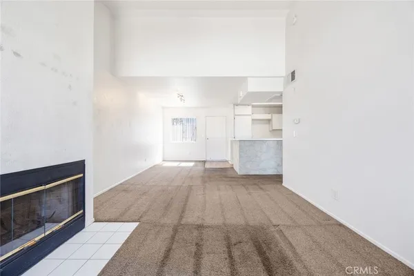 a view of empty room with wooden floor and fireplace