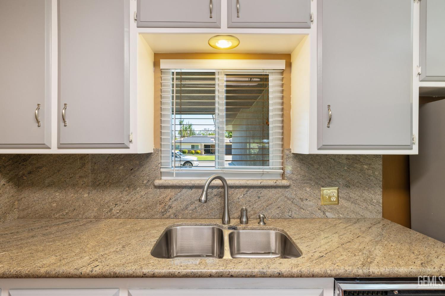 Undisclosed Address Bakersfield, CA 93309 - Photo 20 of 63 a kitchen with granite countertop a sink and a window