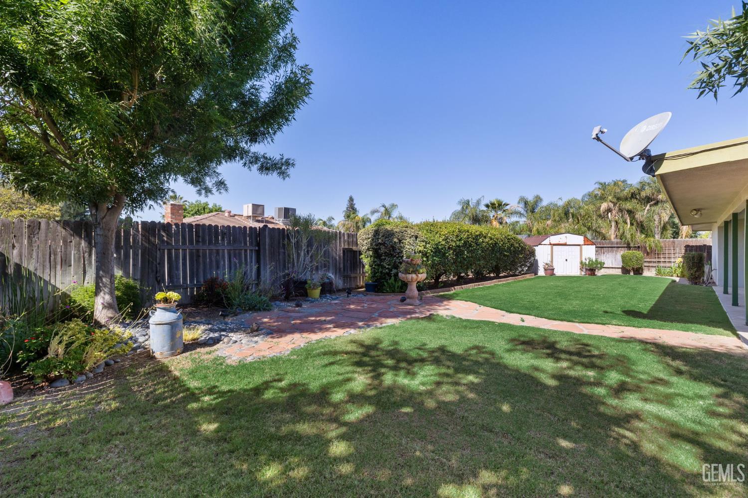 Undisclosed Address Bakersfield, CA 93309 - Photo 33 of 63 a view of a backyard with table and chairs potted plants and wooden fence