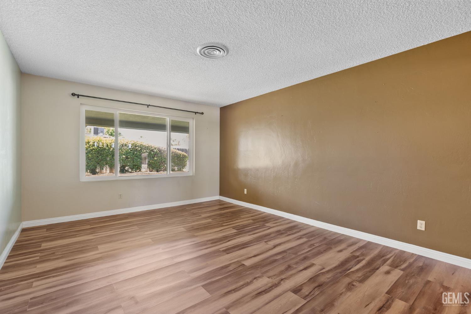 Undisclosed Address Bakersfield, CA 93309 - Photo 43 of 63 a view of an empty room with wooden floor and a window