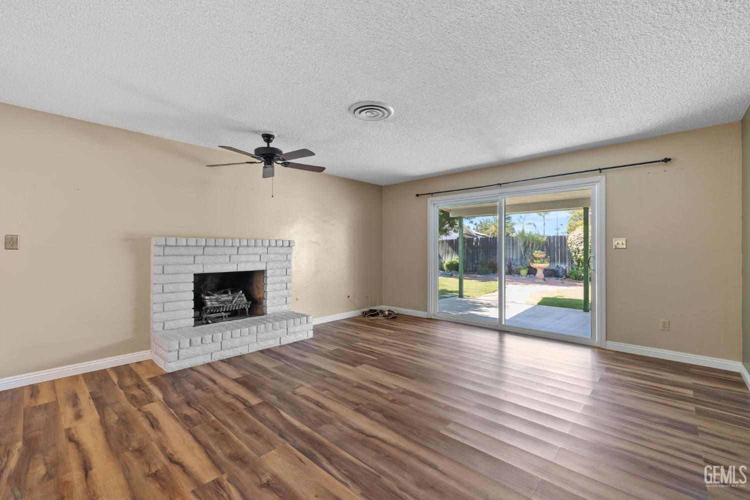 Undisclosed Address Bakersfield, CA 93309 - Photo 45 of 63 a view of an empty room with wooden floor fireplace and a window