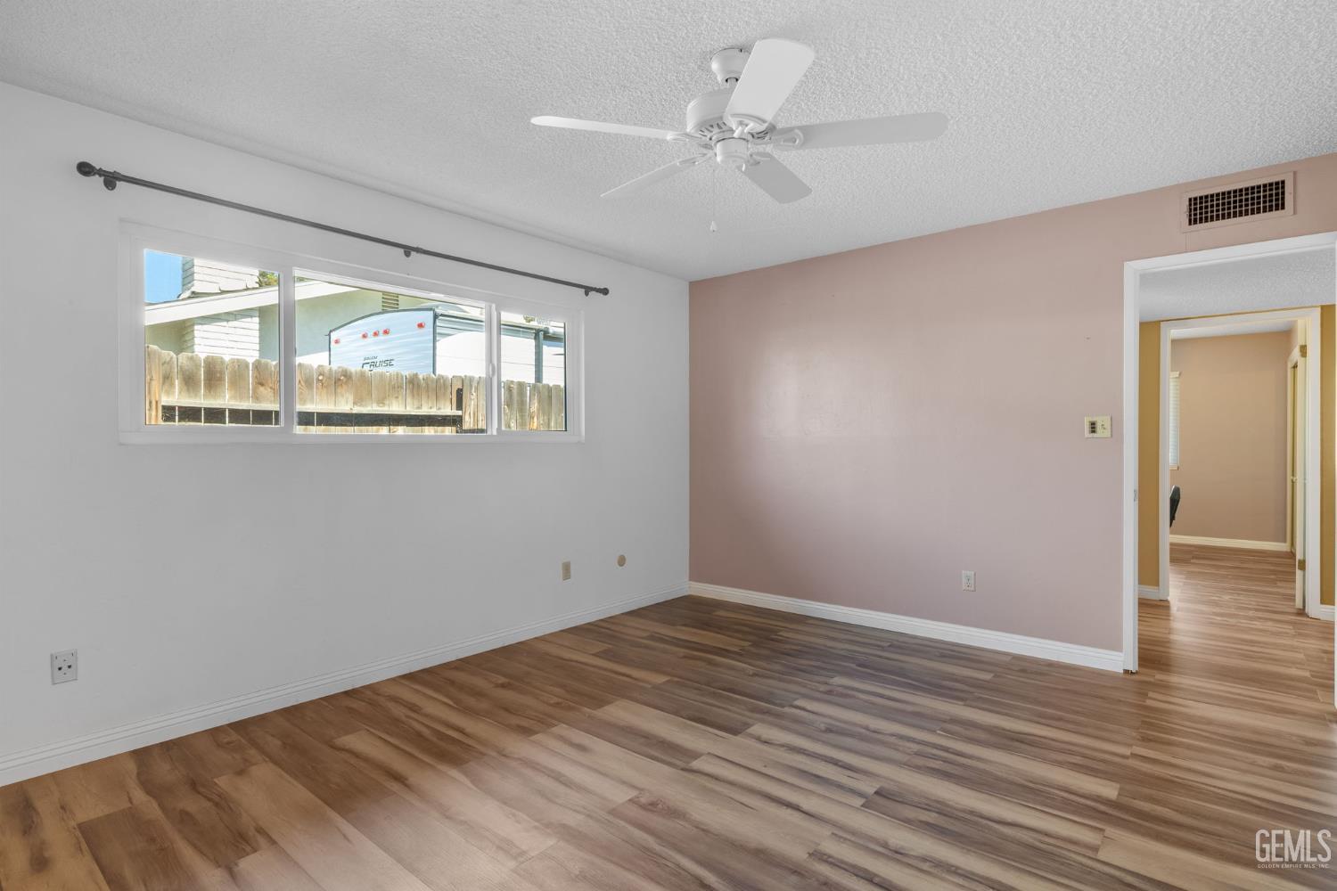 Undisclosed Address Bakersfield, CA 93309 - Photo 56 of 63 a view of an empty room with wooden floor and a window