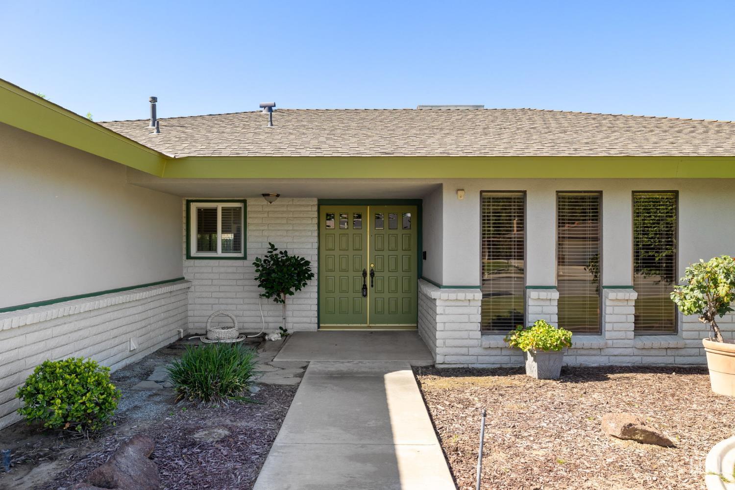 Undisclosed Address Bakersfield, CA 93309 - Photo 9 of 63 a front view of a house with a garden